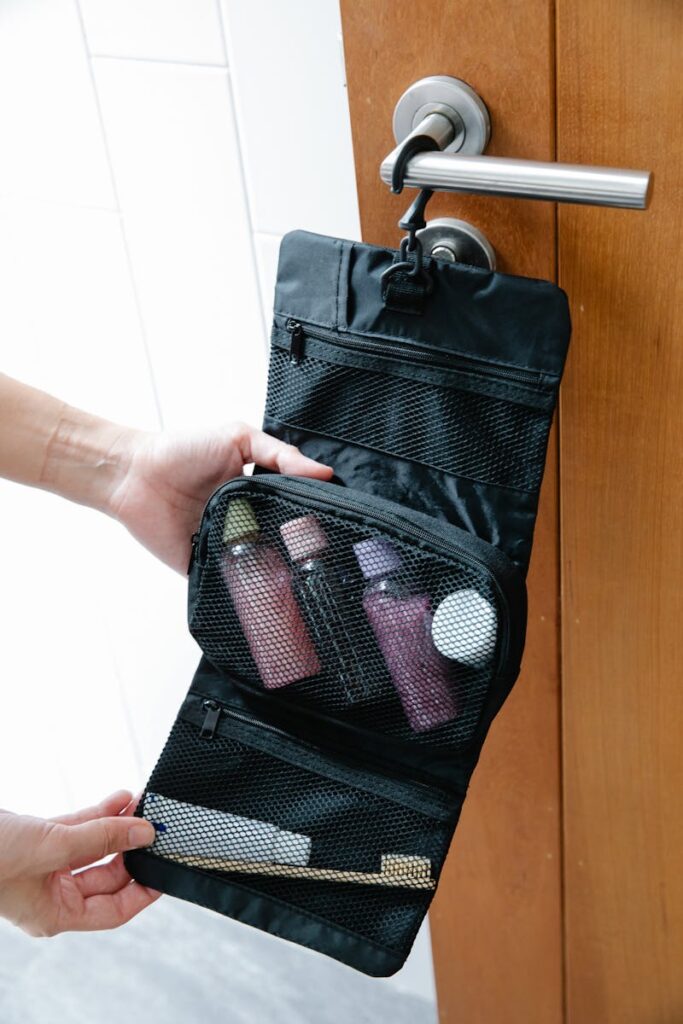 A black toiletry bag with toiletries hanging on a door knob, perfect for travel.