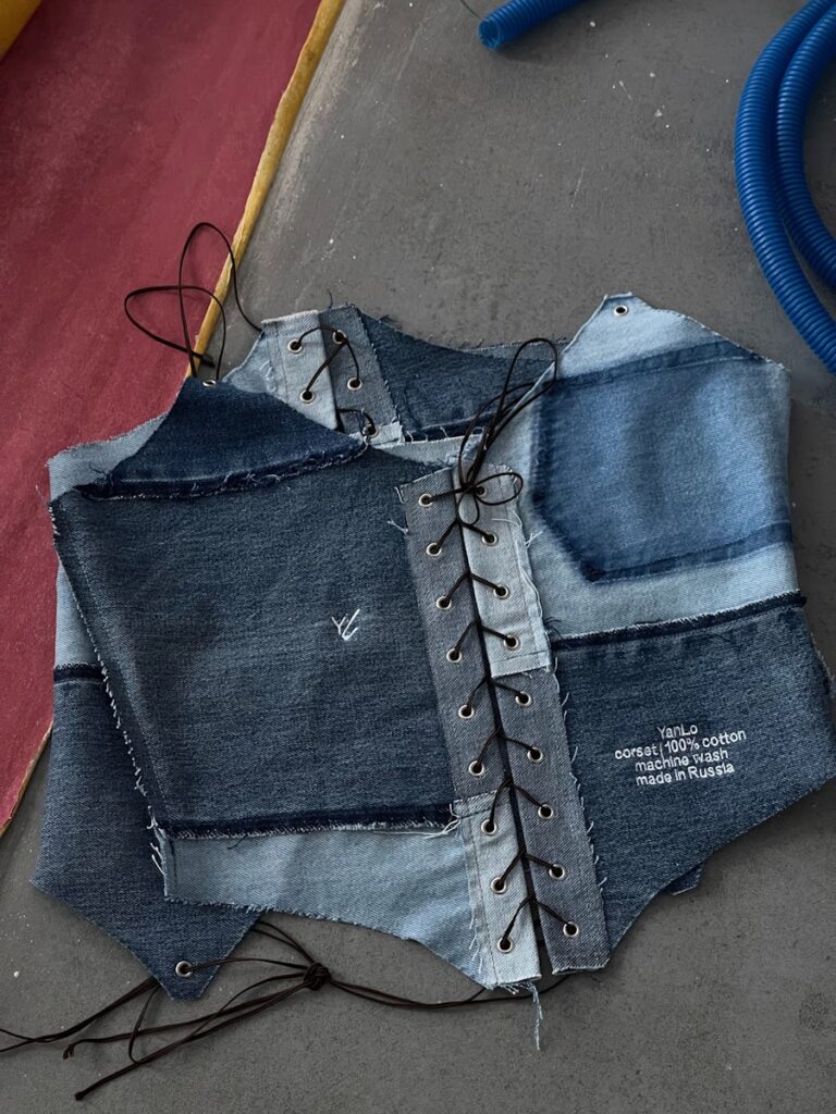 Denim patchwork corset lies on the floor.
