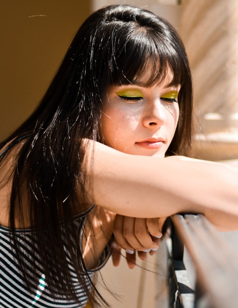 a woman with green eyes and a black and white shirt