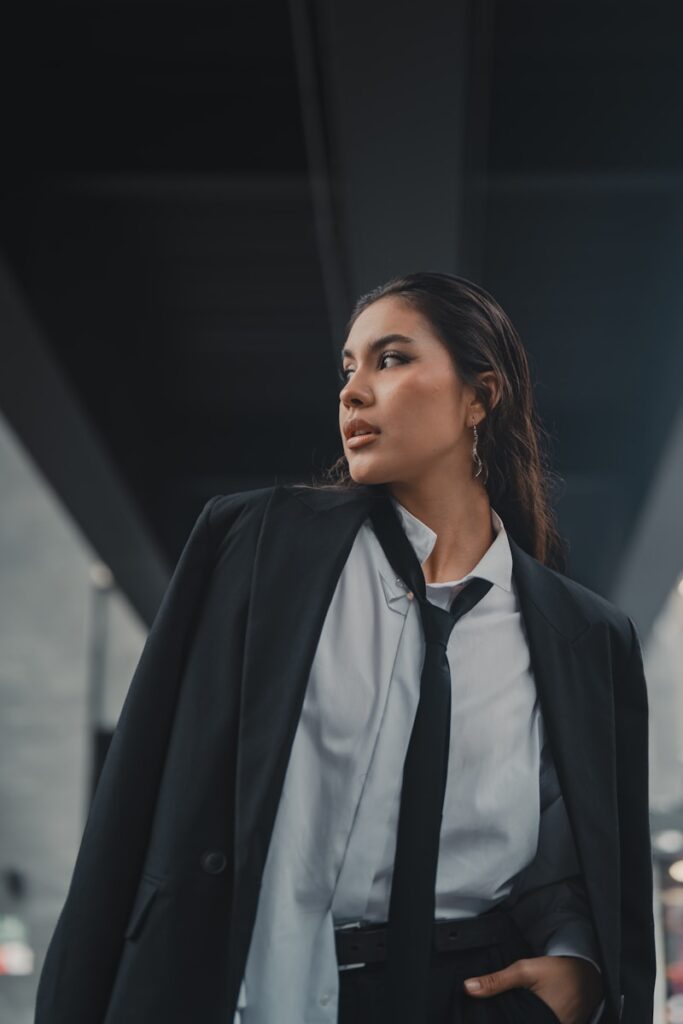 A woman in a suit and tie walking down a street