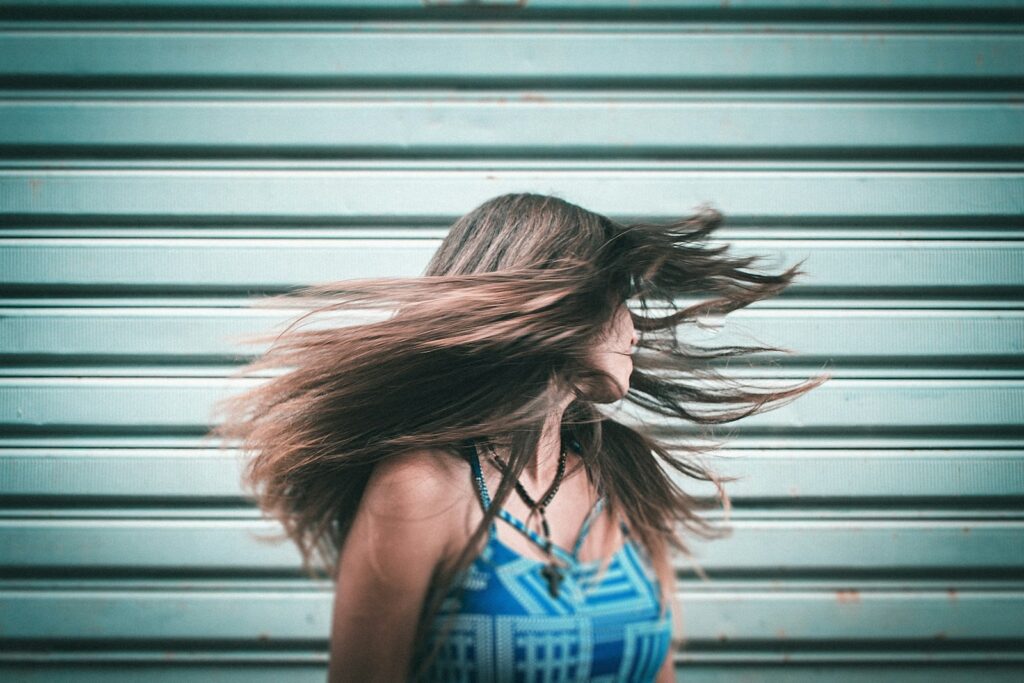 woman in blue tank top standing in front of white roll up door