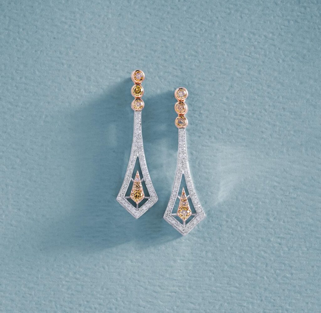 Beautiful diamond earrings displayed on a baby blue textured surface, highlighting luxury and elegance.
