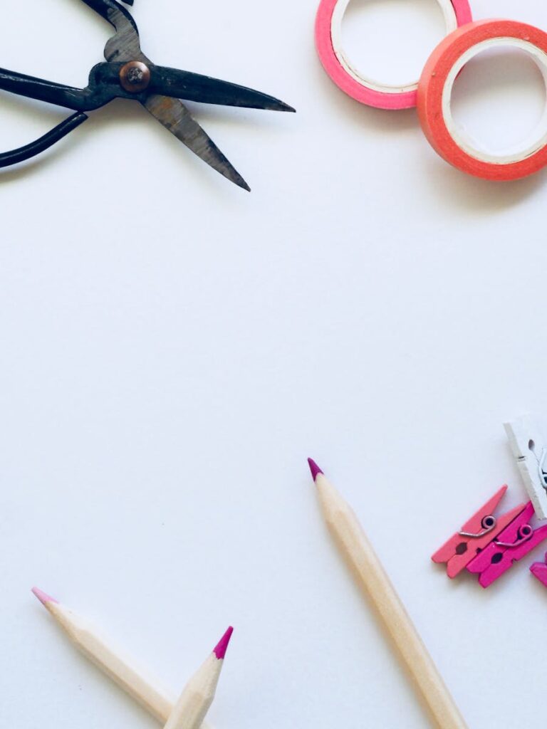 Creative art supplies including pencils, scissors, and tape on a white background.