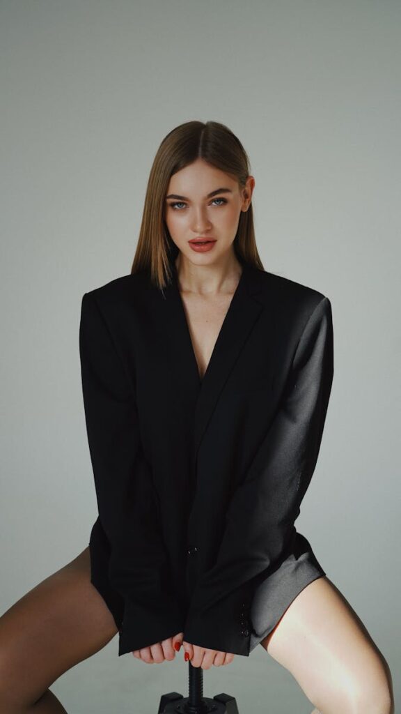 Elegant portrait of a woman sitting confidently in a studio. Modern and fashionable.