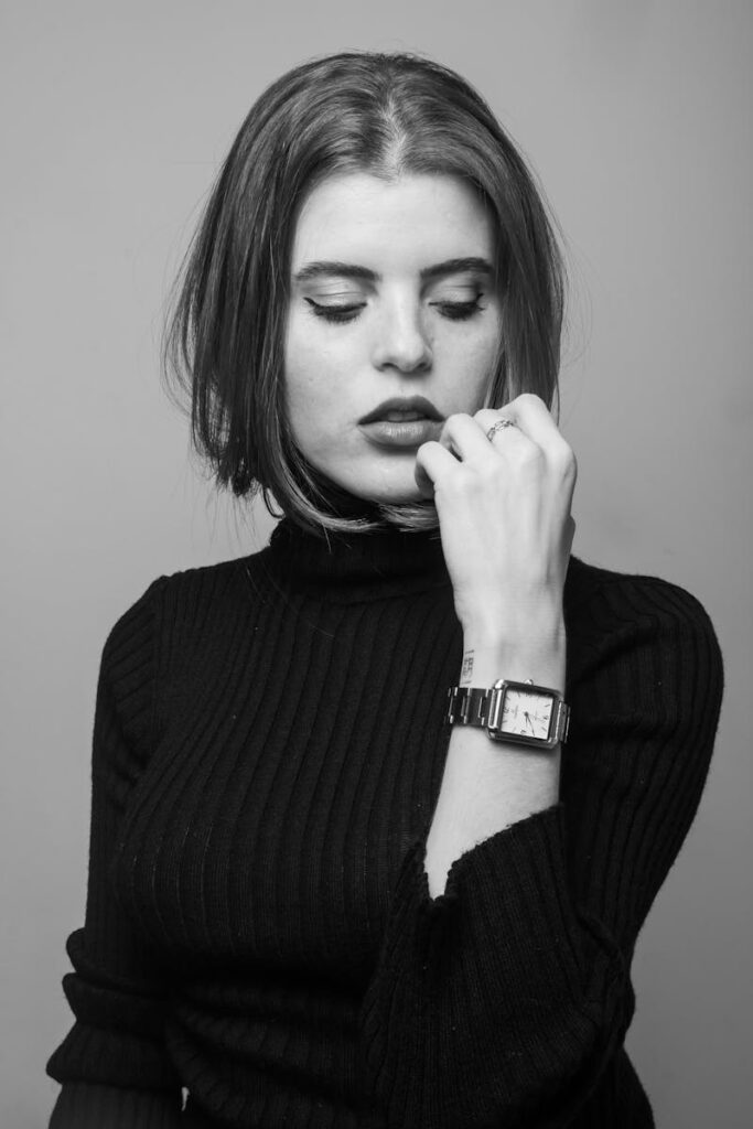 A stylish grayscale portrait of a woman wearing a watch, showcasing elegance.