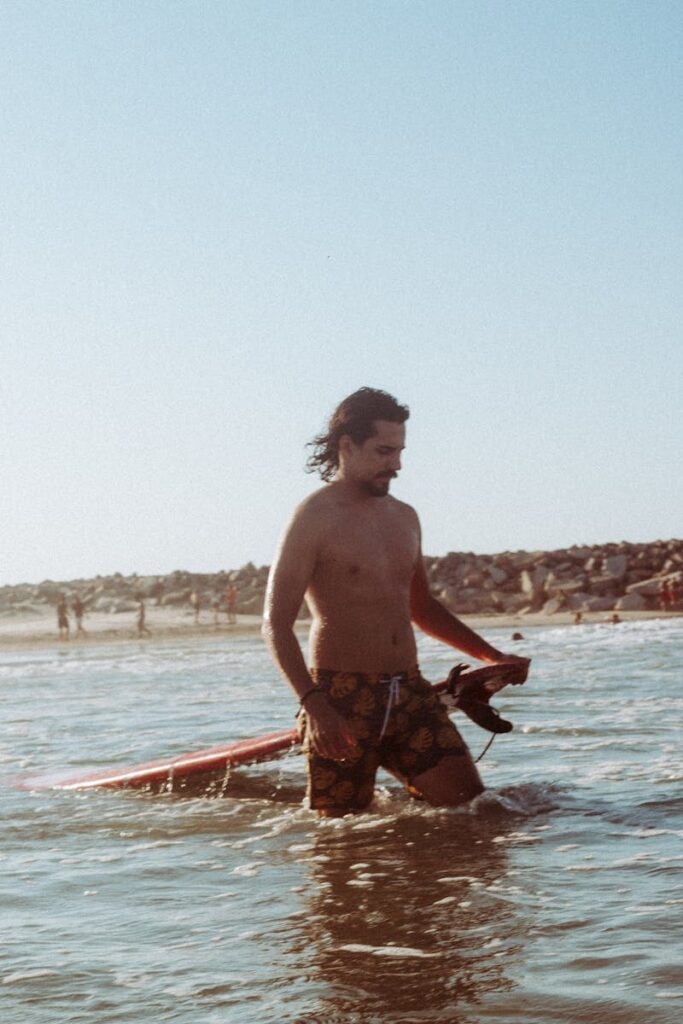 Man with surfboard enjoying a sunny day at the beach in Fortaleza, Brazil.
