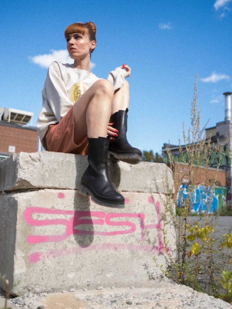 Stylish young woman poses outdoors against graffiti in Montréal, QC.