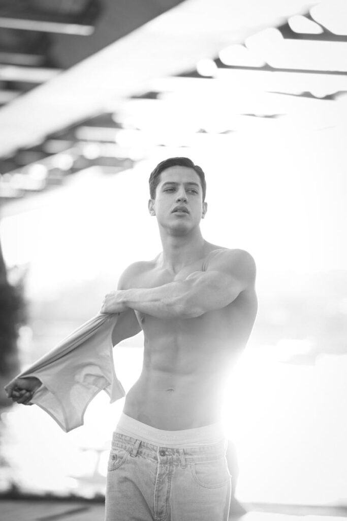 Black and white photo of a shirtless man soaking up sunlight in İstanbul.