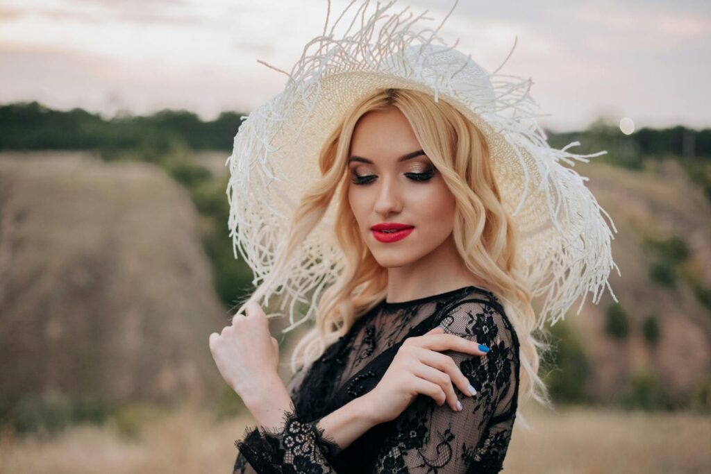 Stylish woman in black lace dress with red lips outdoors in Overath, Germany.