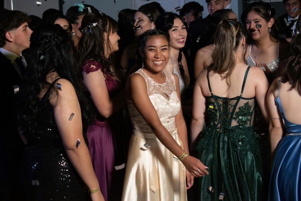 A group of teenagers enjoying a lively party with colorful dresses and smiling faces.