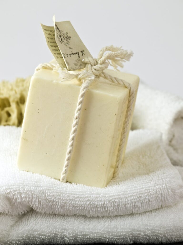 A close-up of handmade soap wrapped with natural rope on white towels, ideal for spa or relaxation themes.