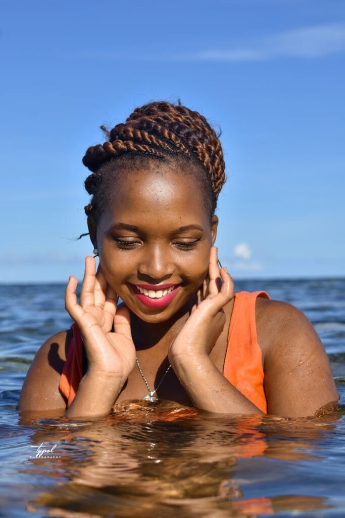Smiling woman in the ocean enjoying a sunny day at the beach, epitomizing leisure and happiness.