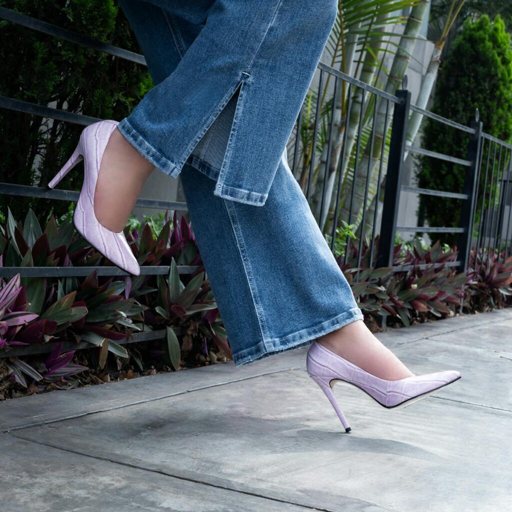 A fashionable outdoor shot of denim jeans paired with chic pink high heels captured on a sunny day.