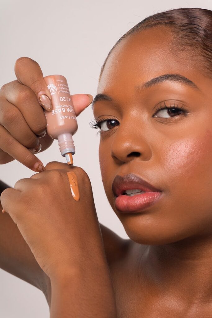 Close-up of a woman applying foundation on hand showcasing skincare and beauty routine.