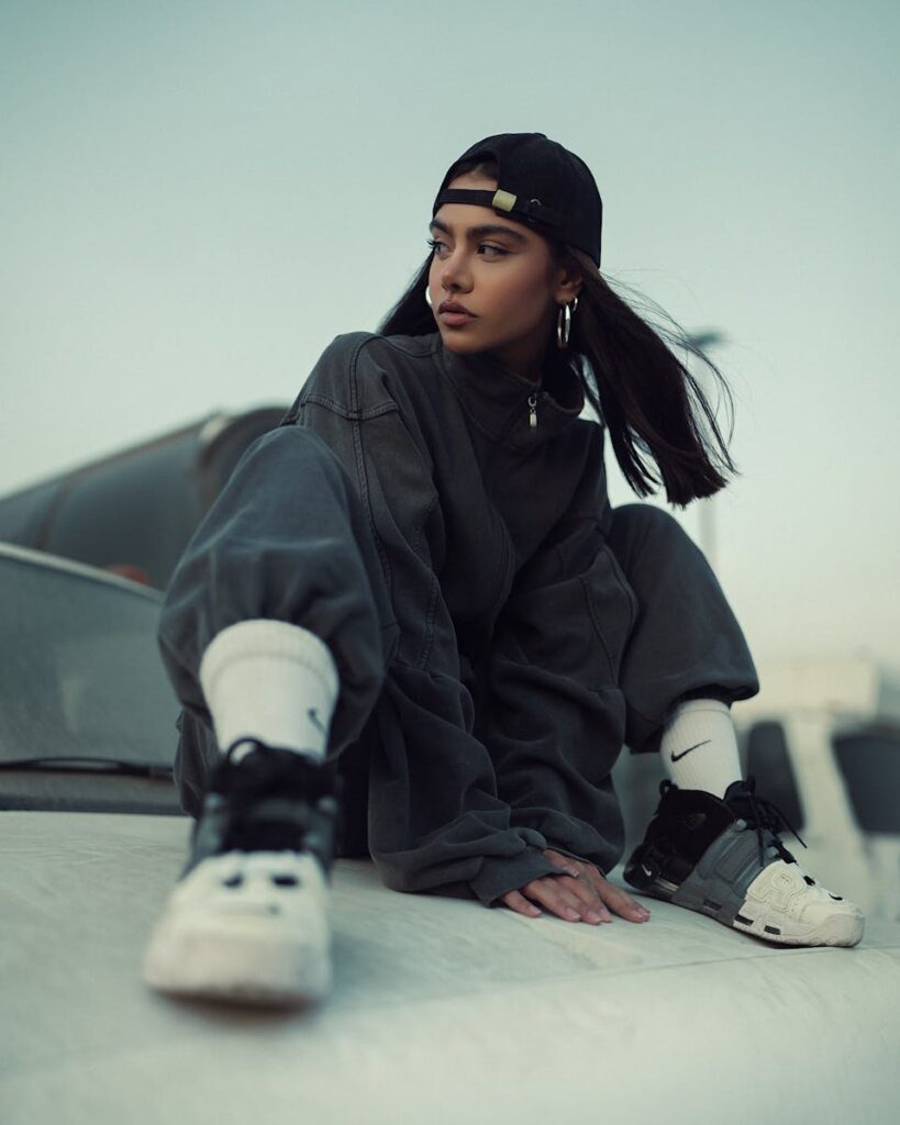 Stylish young woman posing in urban streetwear fashion outdoors.