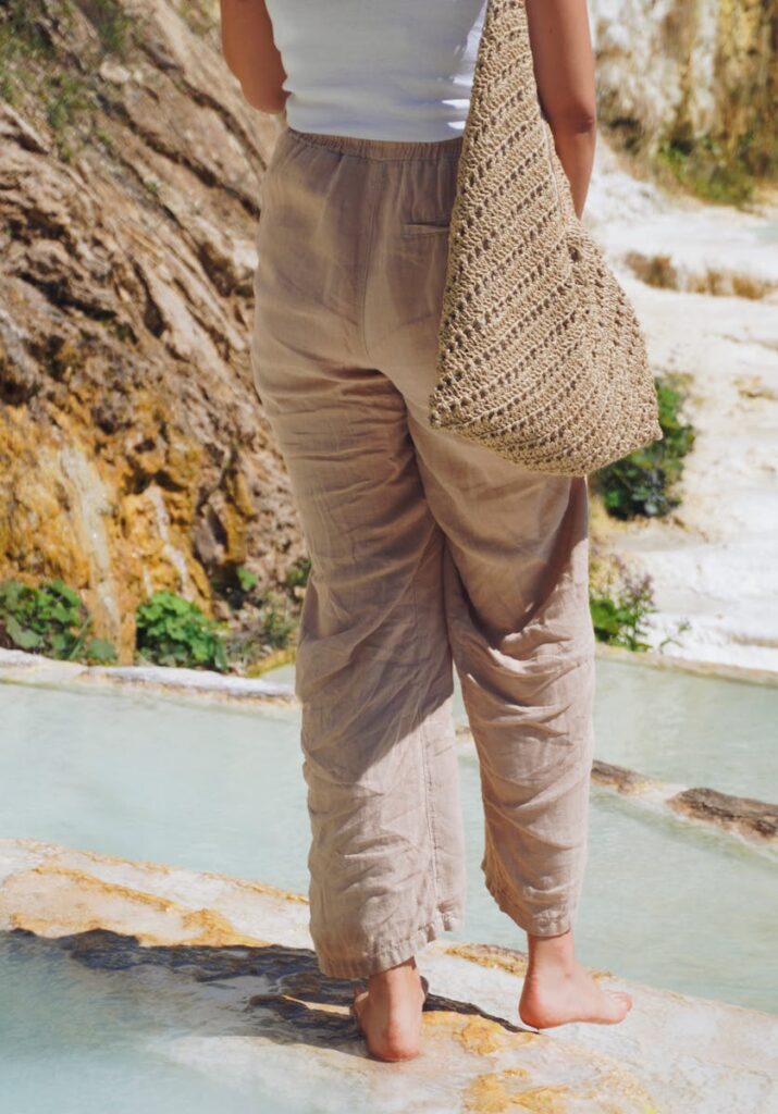 A woman stands barefoot by serene travertine pools in Giresun, Türkiye.