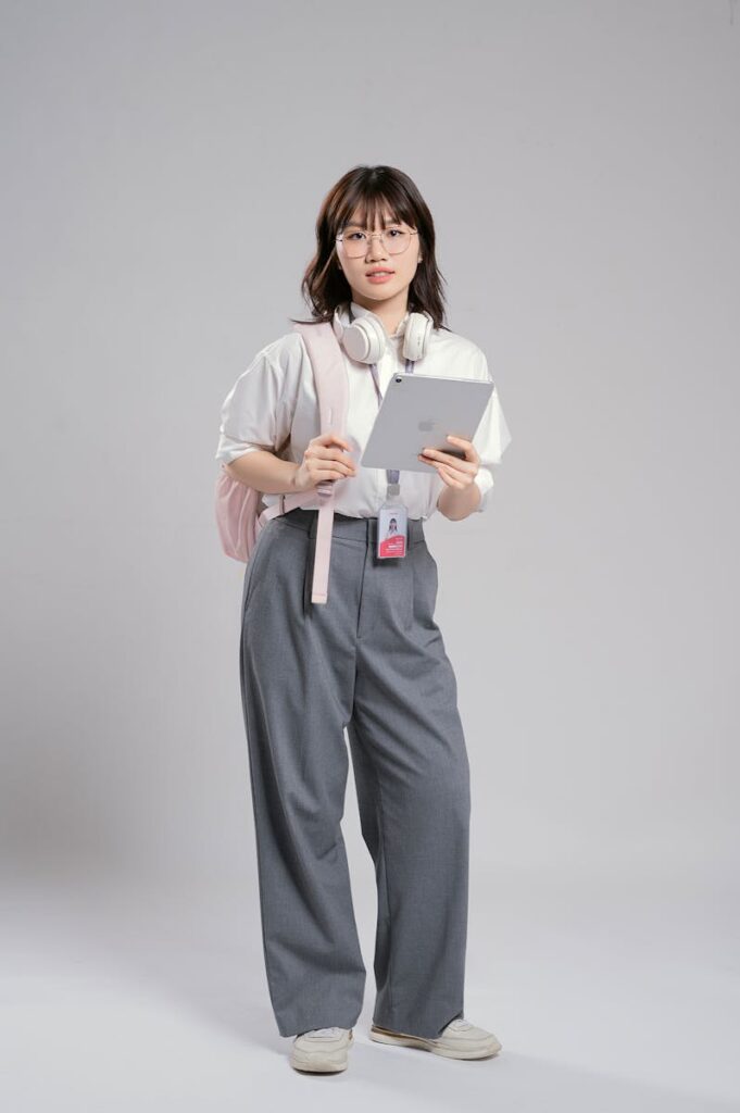 Confident young woman with headphones holding a tablet, ready for study or work.