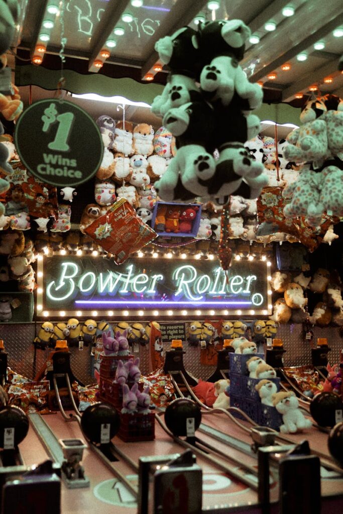 Exciting indoor carnival game setting featuring vibrant plush toys and a glowing 'Bowler Roller' sign.