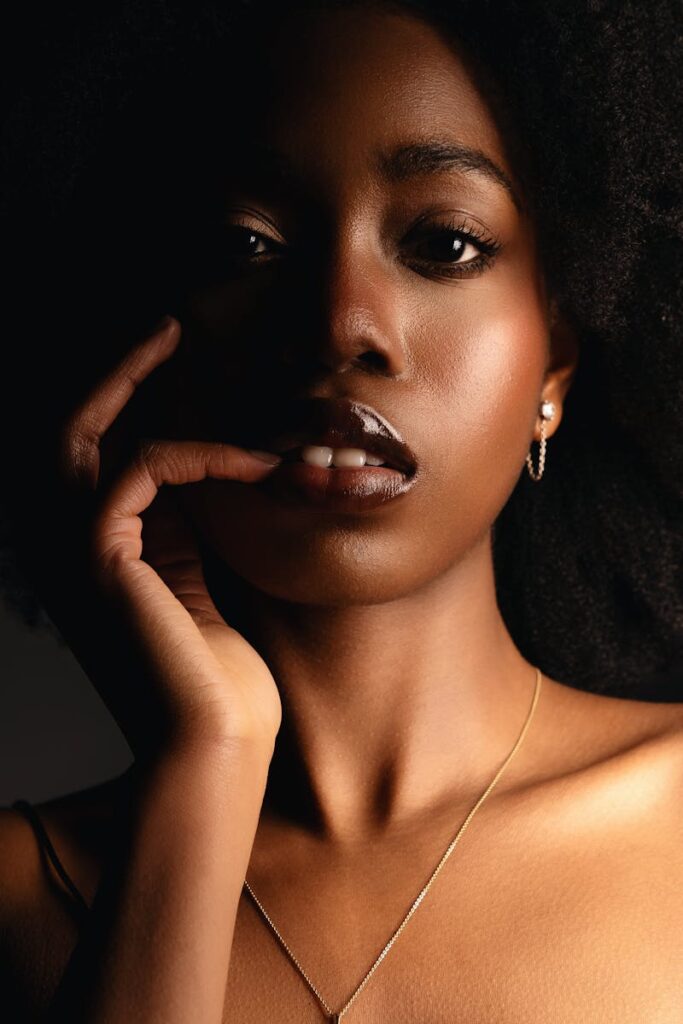 Striking portrait of a model showcasing elegance and bold fashion in studio lighting.