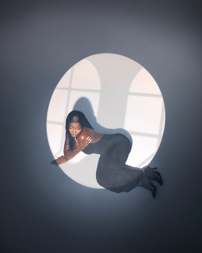 Artistic portrait of a woman in a spotlight circle, creating a dramatic silhouette.