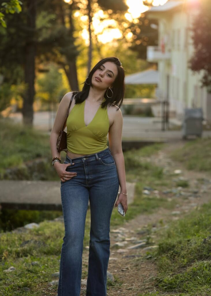 A woman poses outdoors with a relaxed expression and summer fashion style.