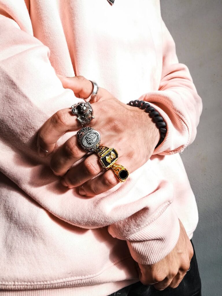 Close-up of a man's hands showcasing multiple stylish rings, a symbol of luxury fashion.