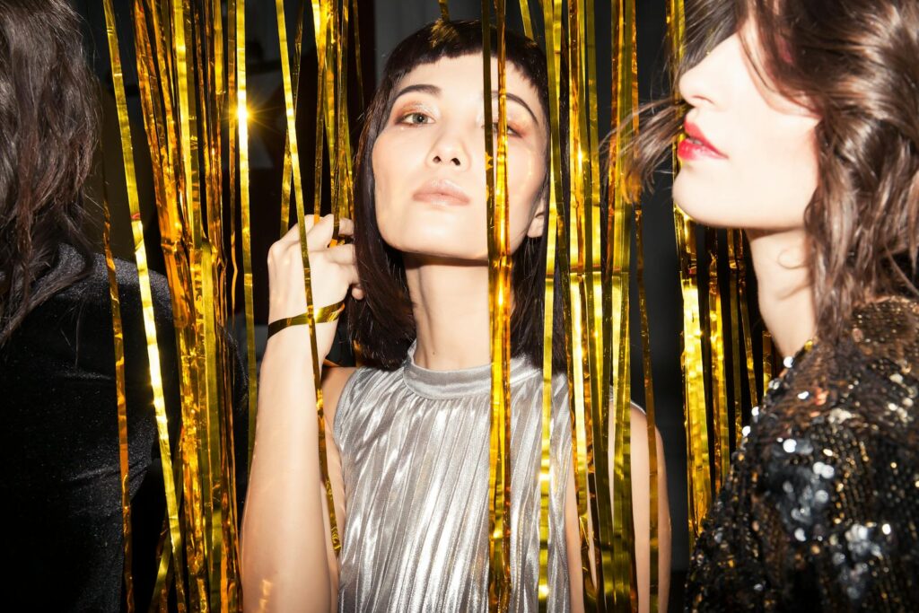 Adult women enjoying a vibrant night party with golden decor, showcasing fashion and celebration.