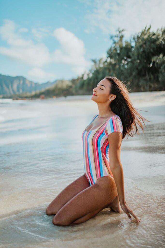 Woman enjoying a sunny day on a tropical beach in a colorful swimsuit.