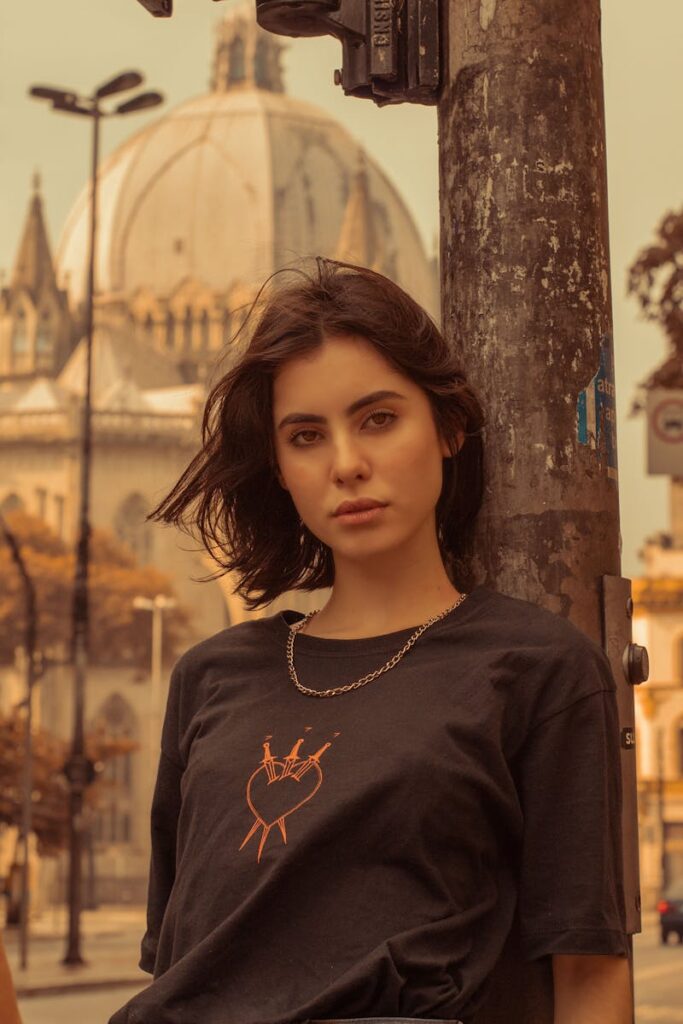 A striking portrait of a woman in São Paulo with iconic architecture in the background.