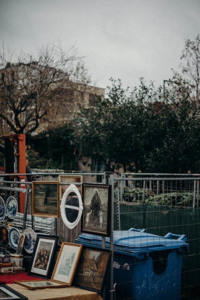 Explore a diverse array of vintage paintings and prints at an outdoor flea market