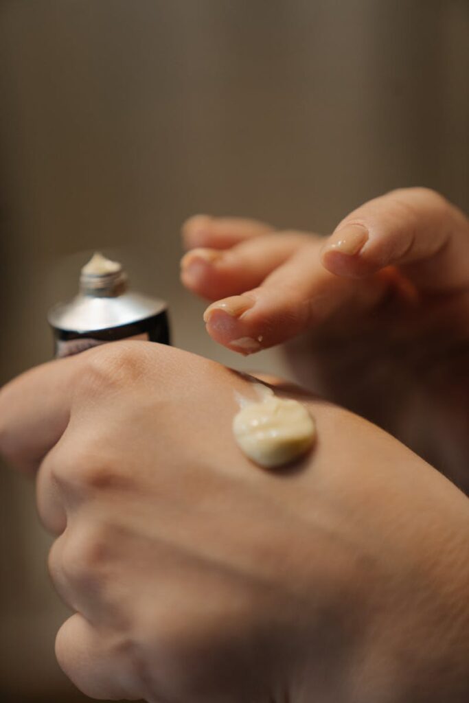Close-up of hands applying skincare cream, highlighting self-care routine.