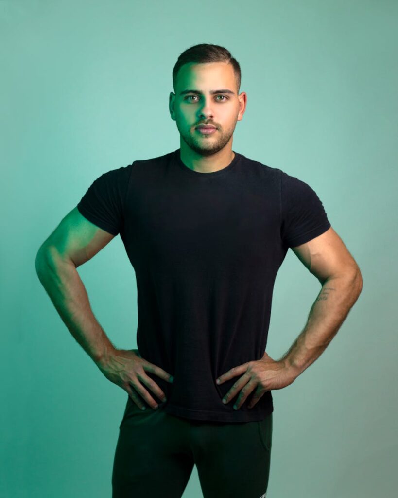 Intense portrait of a strong, muscular man posing confidently in a studio setting.