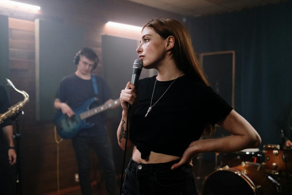 Female singer with microphone in dynamic band performance scene indoors, showcasing live music energy.