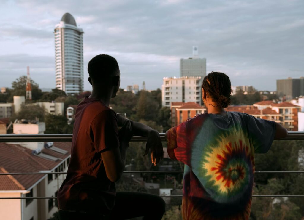 Two people overlook a city skyline at dusk, embracing urban lifestyle and relaxation.