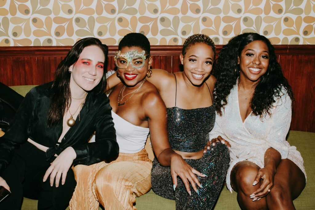 A lively group of friends in festive attire enjoying a New Year's celebration indoors.