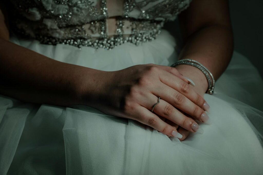 Close-up of a woman in a formal dress displaying elegant hand jewelry, creating a sophisticated and graceful look.