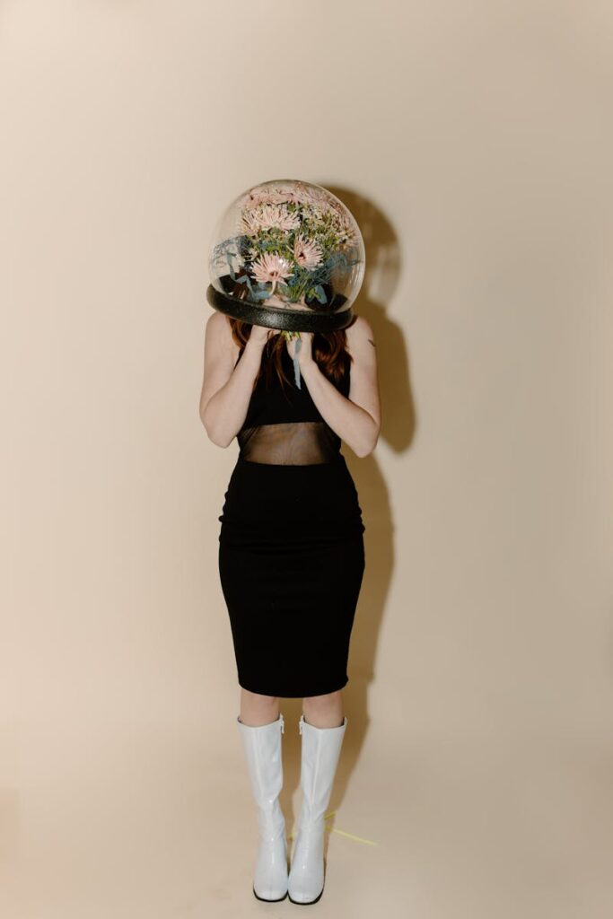 A stylish woman in futuristic attire with a transparent helmet filled with flowers.