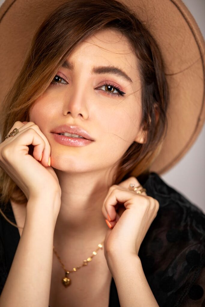 Close-up portrait of a fashionable woman wearing a hat and jewelry.
