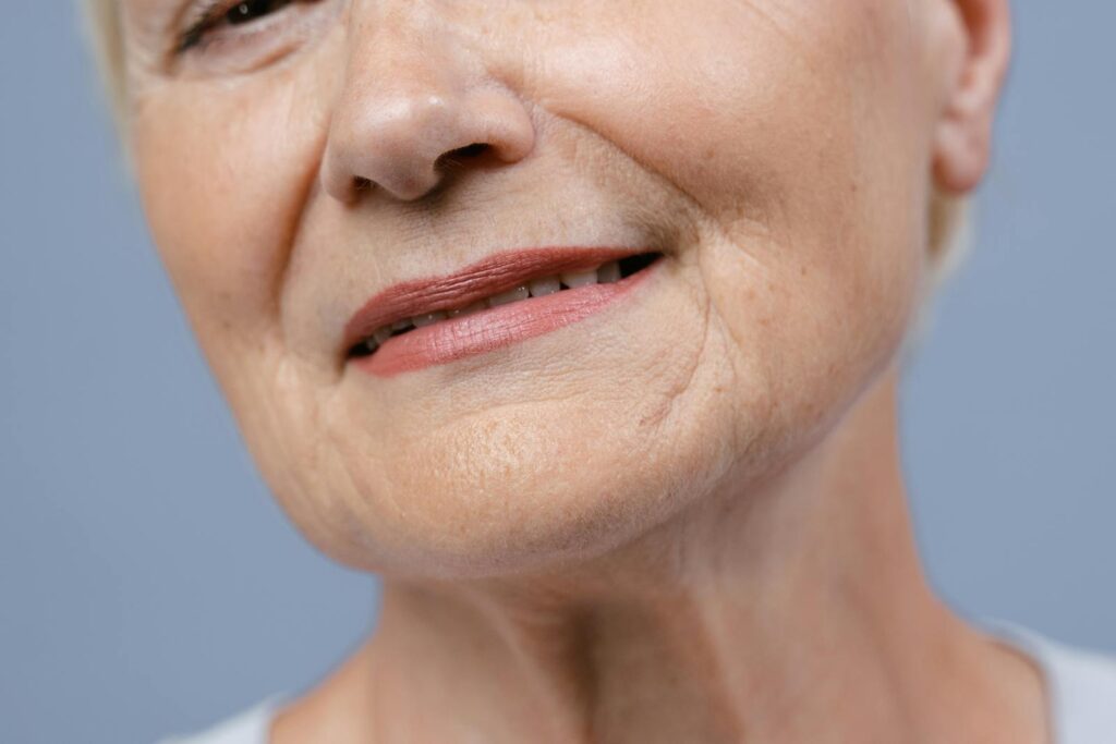 Detailed close-up of an elderly woman's lips and skin, showcasing natural wrinkles.