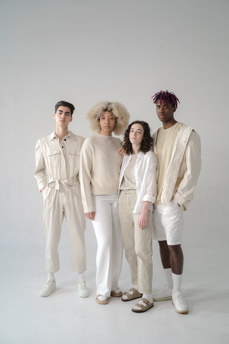 A diverse group of models showcasing modern fashion in a studio setting.