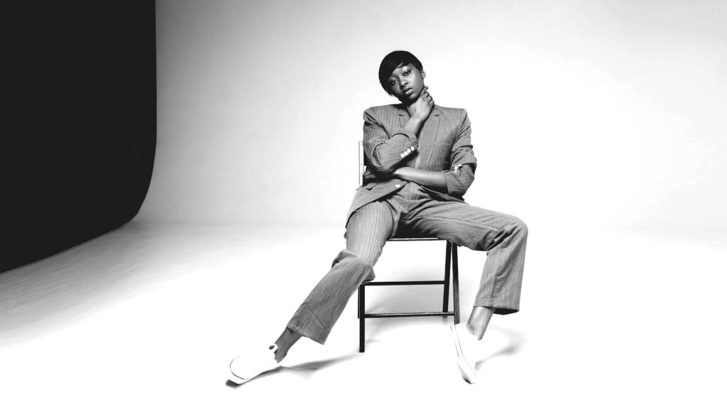 Stylish portrait of a female model in a studio setting, showcasing modern fashion and confident pose.