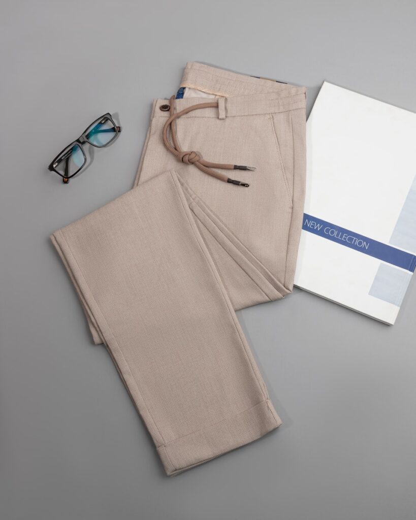 a pair of glasses, a book, and a pair of pants on a table