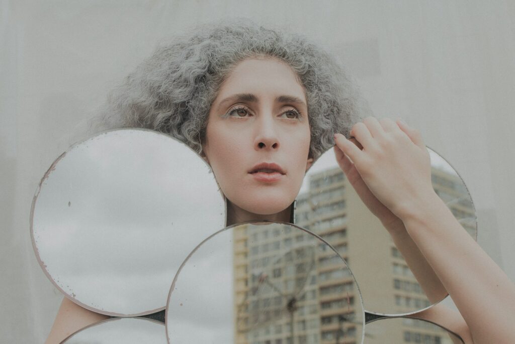 woman holding white round mirror
