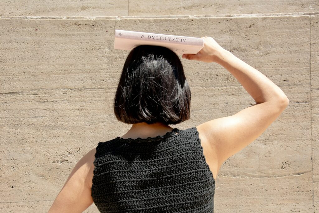 woman holding a book on top of her head