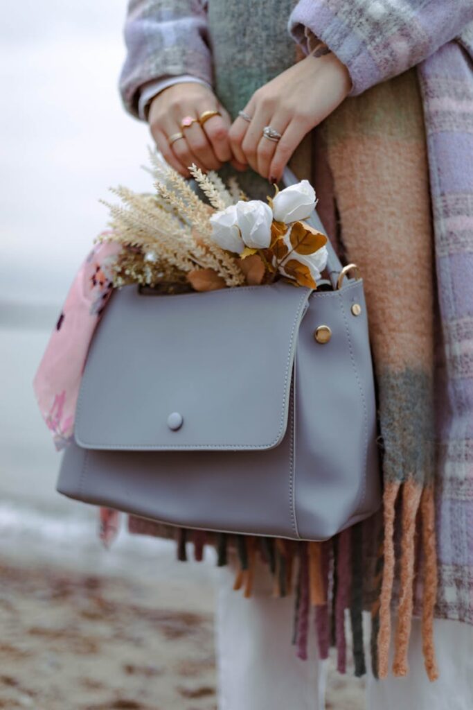 Fashionable woman with floral handbag springtime outdoor setting.