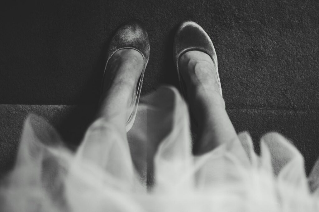 Elegant black and white photo of feet wearing ballet flats, captured from above.