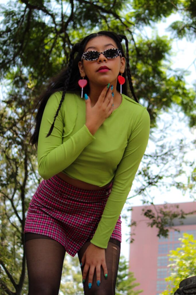 A fashionable woman poses outdoors in a vibrant outfit, showcasing modern style trends.