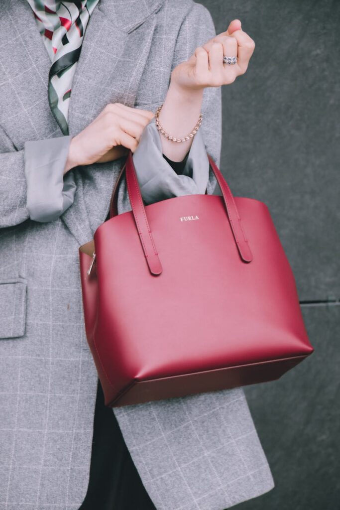 Elegant fashion shot of a woman holding a red handbag, perfect for high-end fashion concepts.
