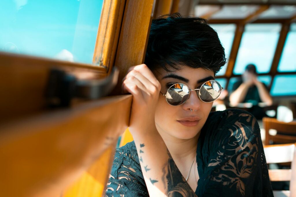 Portrait of a fashionable young woman in sunglasses, relaxing on a boat.