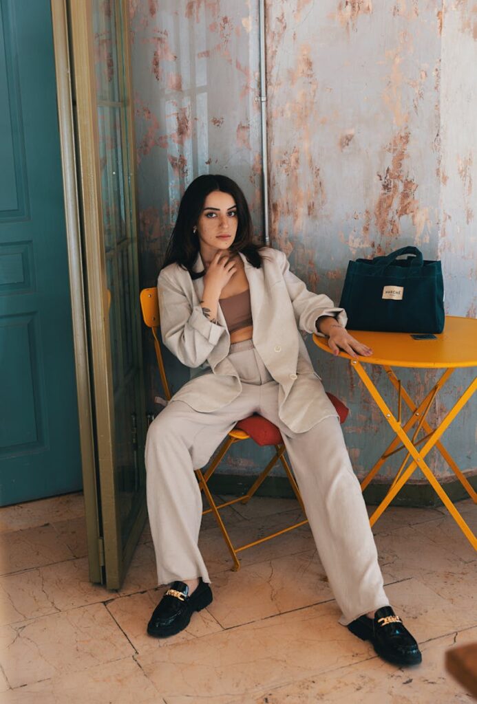 Fashionable woman in beige suit sitting in a contemporary İstanbul café, exuding modern style and elegance.